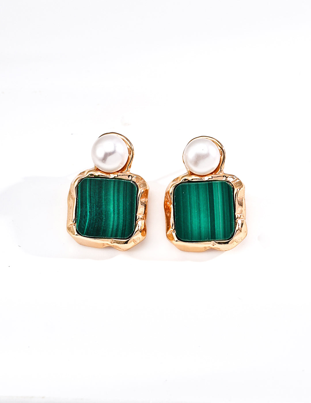Pair of earrings with green square stones and pearl-like tops on a white background