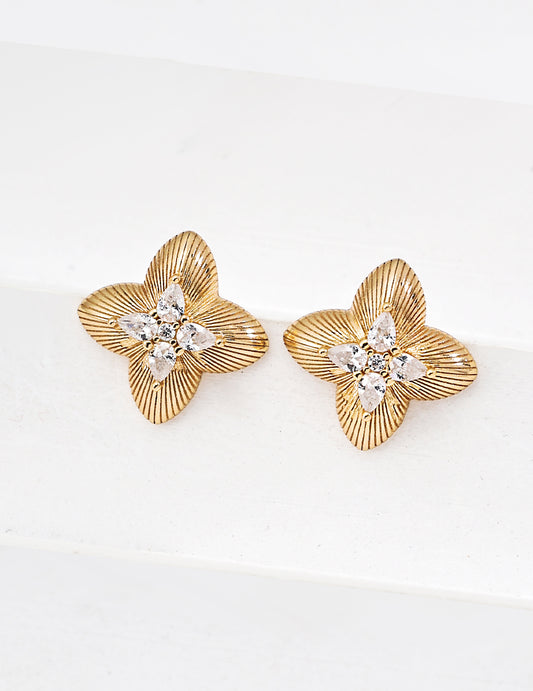 Gold floral earrings with diamond-like centers on a white background