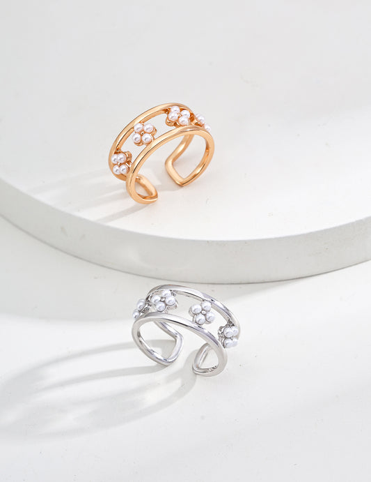 Two open rings, one gold and one silver, on a light gray background