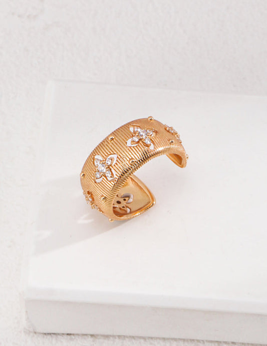 Gold bracelet with floral designs on a white surface