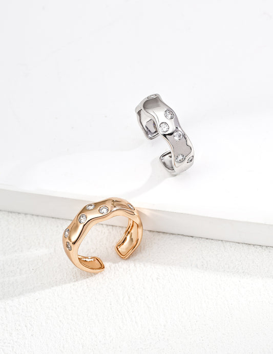Two rings, one gold and one silver, on a white surface with a white background